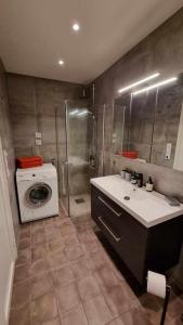 La salle de bains est pourvue d'un lavabo et d'un lave-linge. dans l'établissement Aalesund Holiday Home 4 Bedroom, à Ålesund