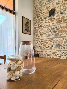 un frasco de cristal lleno de conchas sobre una mesa de madera en splendide maison catalane renovee avec grande terrasse et garage, en Torreilles