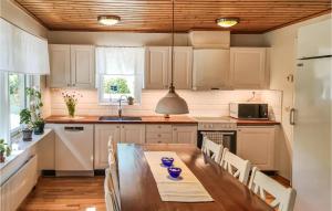 - une cuisine avec une table en bois, des chaises et un évier dans l'établissement Nice Home In Trans With Kitchen, à Tranås