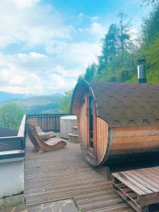 una terrazza in legno con 2 panche e un edificio di B&B Navertino a Borno