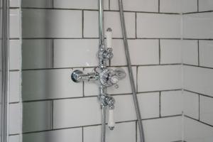a shower in a bathroom with white tiles at Redesdale view with private garden in Moreton in Marsh