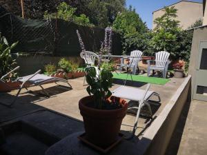 une terrasse avec des chaises, une table et une plante en pot dans l'établissement La Cité médiévale en tableau, à Carcassonne