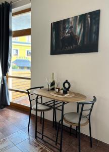 a table and chairs in a room with a window at Apartmán Smrk in Vrbno pod Pradědem