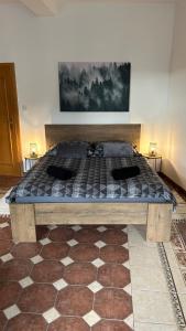 ein großes Bett in einem Schlafzimmer mit einem karierten Boden in der Unterkunft Apartmán Smrk in Vrbno pod Pradědem