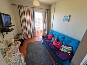 a living room with a blue couch with pillows on it at ستوديو جولف بورتو مارينا in El Alamein