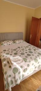 a bed with a green and white comforter on it at Apartments Burazer in Šibenik