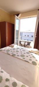 a bedroom with a large bed with a large window at Apartments Burazer in Šibenik
