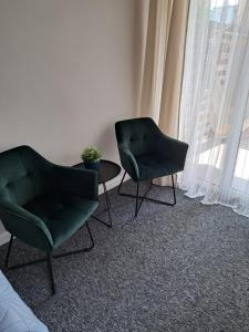 two chairs and a table in a room with a window at Twoja Przystań in Władysławowo