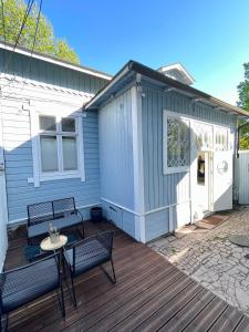 une petite maison bleue avec deux bancs sur une terrasse dans l'établissement Kapteeninmökki, à Naantali