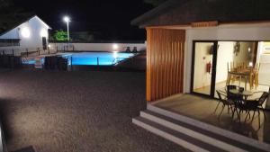 una casa con piscina por la noche en School Motorhome Park, 