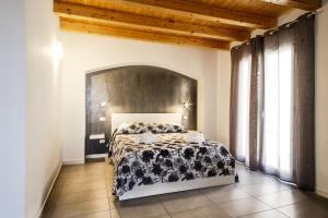 a bedroom with a bed with a black and white blanket at Opera Suite in Castellammare del Golfo