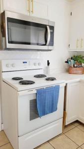 a kitchen with a white stove with a microwave at Greensboro Downtown House in Greensboro