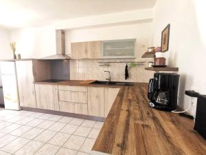 a kitchen with wooden cabinets and a coffee maker at Maison O Volets Bleus Calme Jardin in Miramas