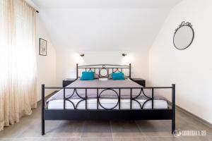 1 dormitorio con cama negra y almohadas azules en MAK BASTA en Bajina Bašta