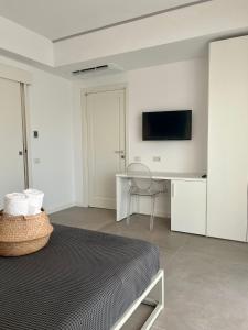 Schlafzimmer mit einem Bett, einem Schreibtisch und einem TV in der Unterkunft Il Volo in Sperlonga