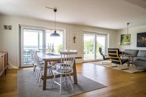 a dining room and living room with a table and chairs at Exclusive tranquil villa by the sea, boat available in Drottningskär