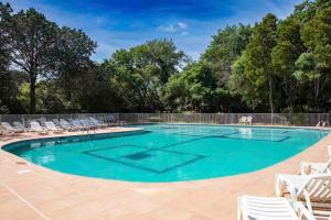 a large swimming pool with chairs and a fence at Appartement au centre de Saint-tropez avec terrasse in Saint-Tropez +10 photos