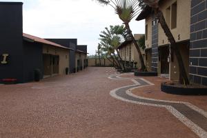 una calle adoquinada con palmeras y un edificio en SAFIRA MOTEL II en Fernandópolis