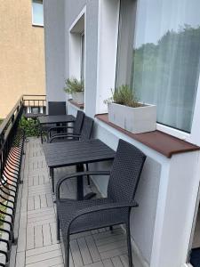 a balcony with tables and chairs and a window at Dom na Północy in Władysławowo
