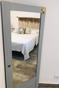 a mirror reflecting a bed in a bedroom at Casa 1-Quinta dos Penedos in Portalegre