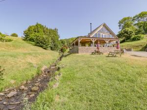une maison assise au sommet d'une colline herbeuse dans l'établissement Vine Cottage, à Abergavenny