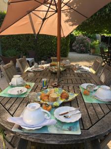 une table avec une théière et des assiettes de nourriture dans l'établissement Chambre d'hôtes Dallara, à Entraigues-sur-la-Sorgue