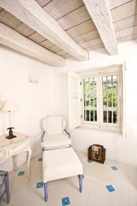 Una silla blanca en una habitación con escritorio y ventana en Hotel Casa Quero, en Cartagena de Indias