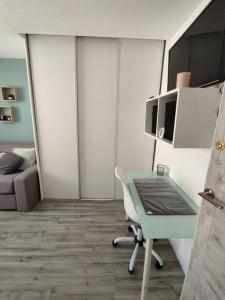 ein Wohnzimmer mit einem Schreibtisch und einer Mikrowelle in der Unterkunft 3 Pièces proche mer et aéroport in Nizza