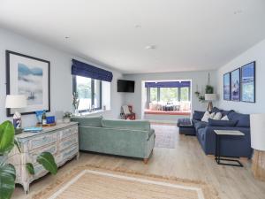 a living room with a blue couch and a table at Ynys Faelog in Menai Bridge