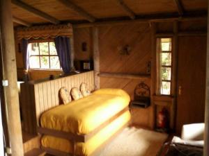 1 dormitorio con 1 cama en la esquina de una habitación en Chiloe, Cabaña la Pincoya, en Queilén