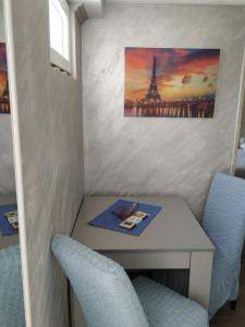 einen Tisch mit zwei Stühlen und ein Bild des Eiffelturms in der Unterkunft Studio Kaća in Cetinje