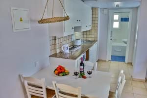 a kitchen and dining room with a white table and chairs at Aktea Beach Village in Ayia Napa