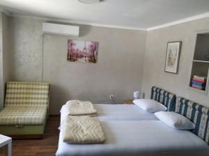 1 Schlafzimmer mit 2 Betten und einem Stuhl in der Unterkunft Studio Kaća in Cetinje