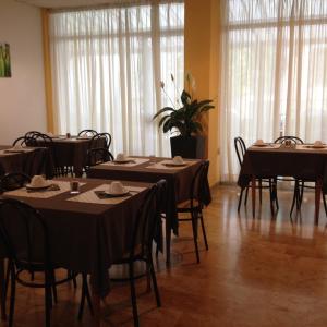 فندق كابيتول في بيزارو: غرفة طعام مع طاولات وكراسي في غرفة