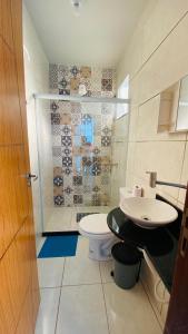 łazienka z toaletą i umywalką w obiekcie Hanuá Beach House w mieście Guarapari