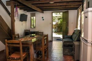 uma sala de jantar com uma mesa e um sofá em Cabañas PATALSUELO em Barra de Valizas