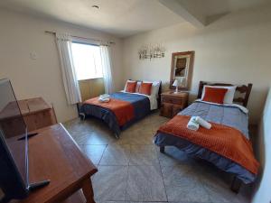 a bedroom with two beds and a tv and a mirror at Astral de Minas in Tiradentes