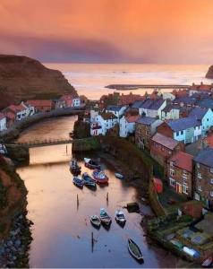 a group of boats in the water in a town at The Blue Porch Staithes in Staithes