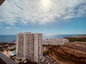 an aerial view of a tall white building and the ocean at Gold Sunset in Adeje