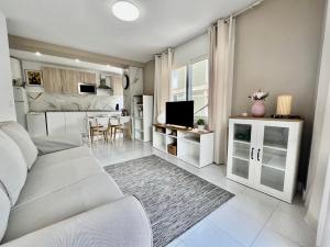 uma sala de estar com um sofá branco e uma cozinha em Apartments Platja d’Aro Center em Platja d'Aro