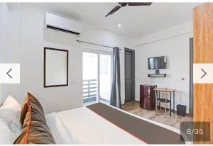 Cette chambre comprend un lit et une télévision. dans l'établissement Townhouse HOTEL CLOUD BAY, à Gurgaon