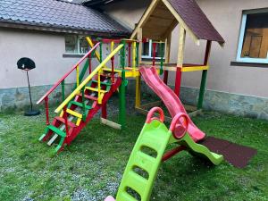 a playground with a slide and a play structure at Pensiunea Flora in Cîrţişoara