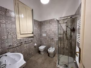 a bathroom with a toilet and a sink and a shower at Osorio 74 Apartments in Trapani +19 photos