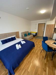 een slaapkamer met een groot blauw bed en een tafel bij Apartman Zlatanovic Jagodina in Jagodina