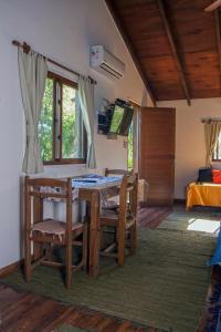 a dining room with a table and chairs and a bed at Cabañas PATALSUELO in Barra de Valizas