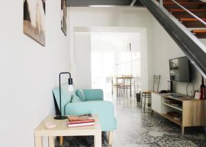 een woonkamer met een blauwe stoel en een tafel bij Casa da Cal Branca in Évora