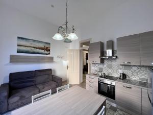 a kitchen and living room with a couch and a table at Osorio 74 Apartments in Trapani