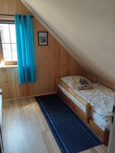 ŁebczにあるWakacyjny Łebczのベッドルーム1室(青いカーテン付きのベッド1台付)