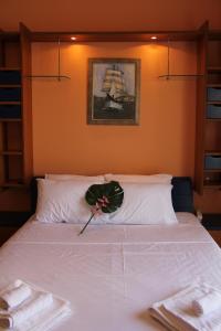 a bedroom with a white bed with towels on it at Captain's Lodge in Ermoupoli
