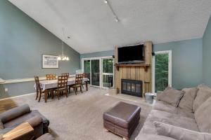 ein Wohnzimmer mit einem Sofa, einem Tisch und einem TV in der Unterkunft Harbor Cove's Scenic Solitude in Harbor Springs